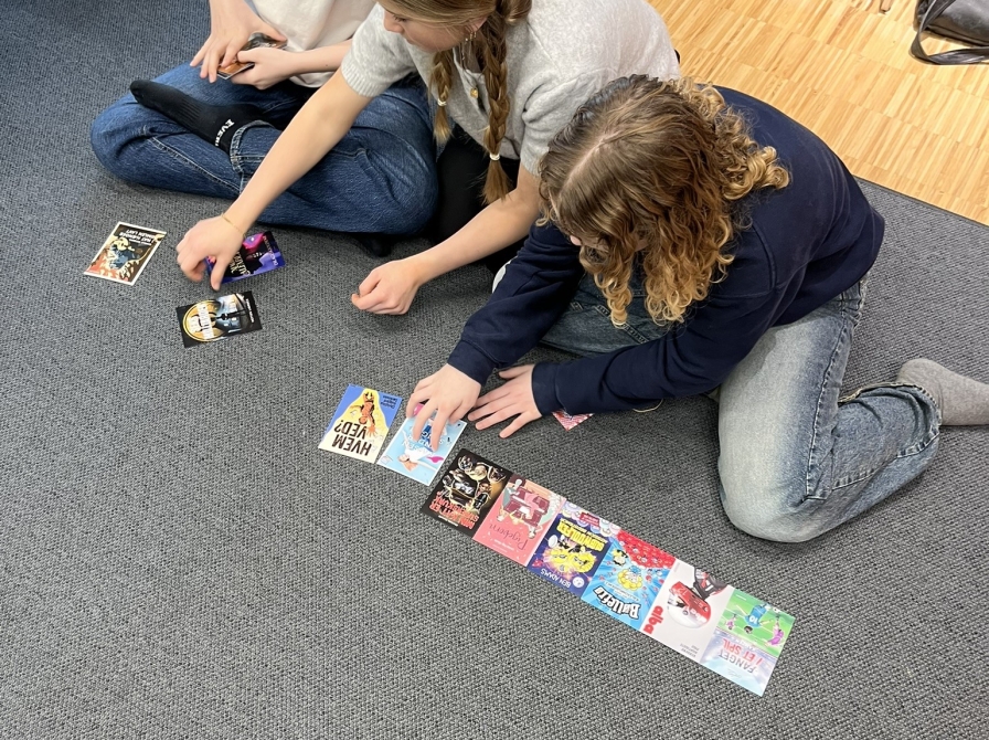 Tre piger, der sidder med bogforsider